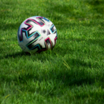 Close-up of a colorful soccer ball on a lush green grass field.